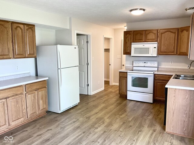 1327 Blue Ridge Ln, Brownsburg, IN 46112 - kitchen featuring white appliances, a sink, brown cabinets, and light countertops