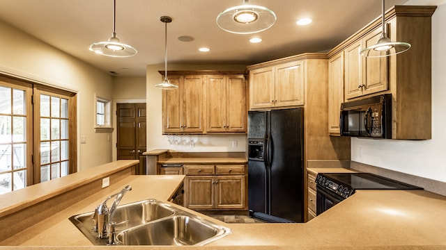 kitchen featuring black appliances, pendant lighting, and sink