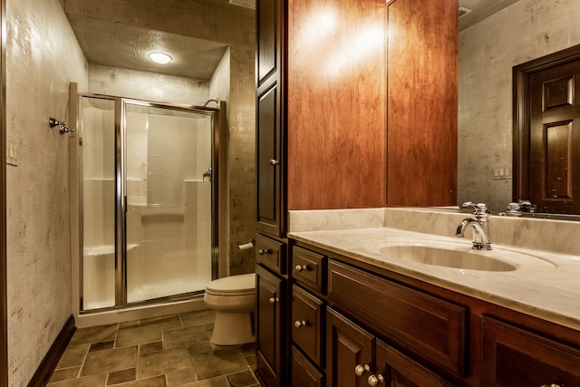 bathroom with vanity, toilet, and a shower with shower door