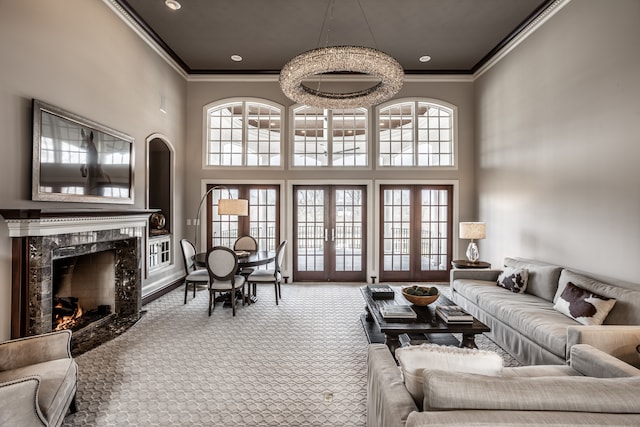 living room featuring crown molding, a fireplace, carpet, and a high ceiling