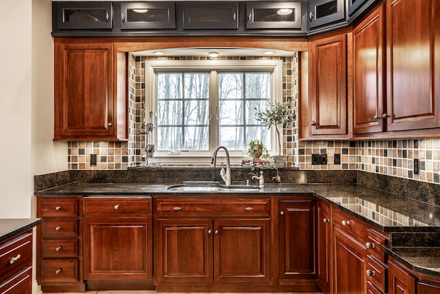 kitchen featuring tasteful backsplash, sink, and dark stone counters