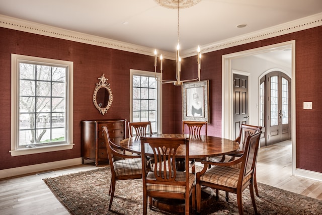 dining space with a healthy amount of sunlight, light hardwood / wood-style floors, and french doors