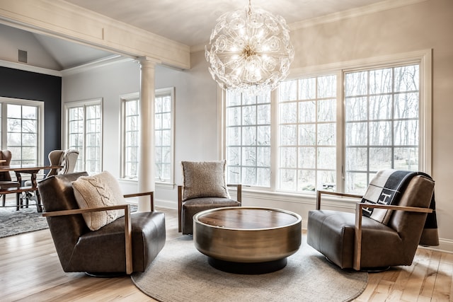 sitting room featuring decorative columns, a chandelier, lofted ceiling, and light hardwood / wood-style floors