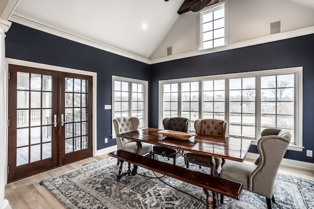 dining space featuring plenty of natural light, light hardwood / wood-style floors, high vaulted ceiling, and french doors