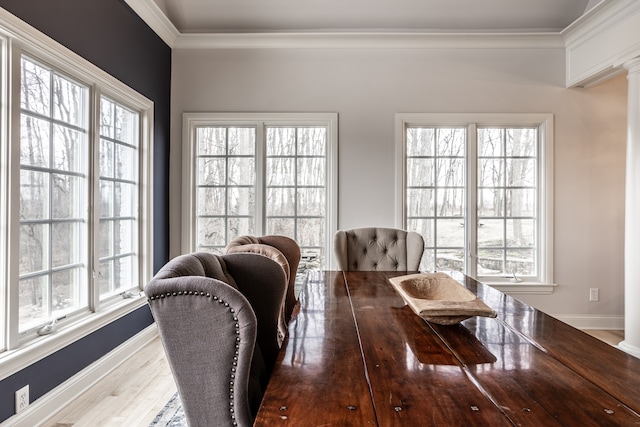 dining area featuring decorative columns, crown molding, and a healthy amount of sunlight