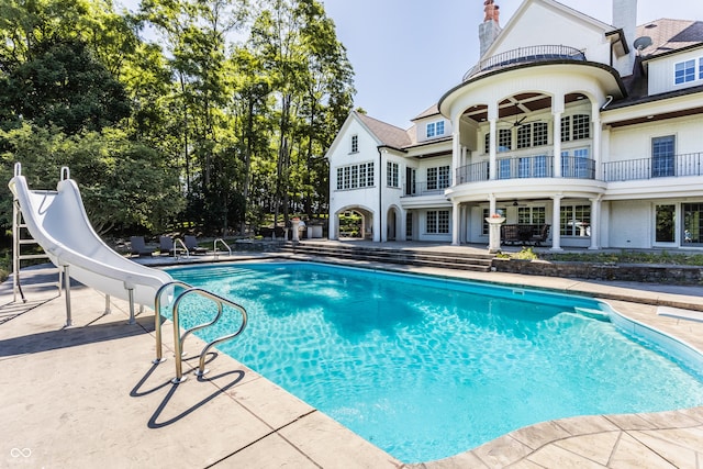 view of pool with a patio and a water slide