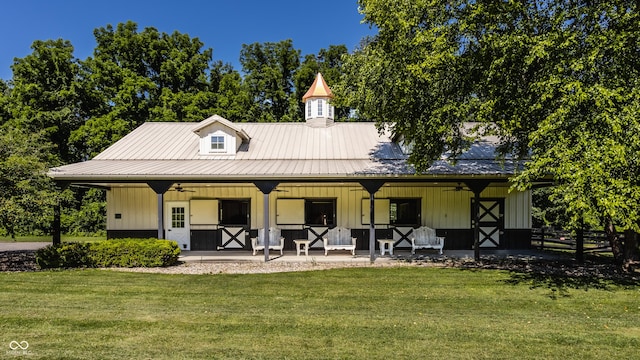 rear view of property featuring ceiling fan and a lawn