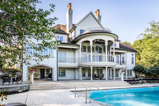 rear view of house with a patio area, ceiling fan, and a balcony