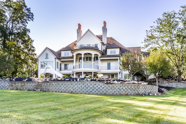 back of property with a balcony and a yard