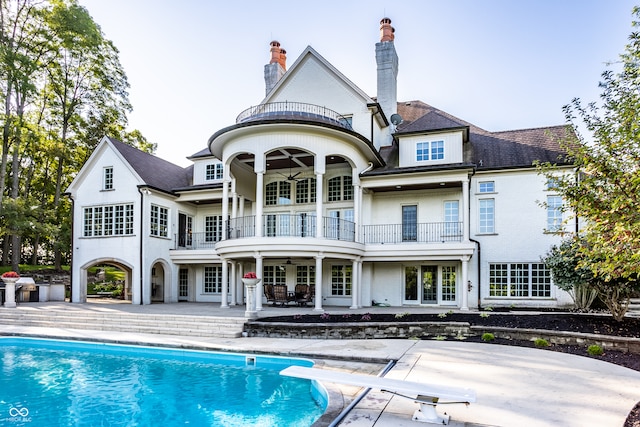 back of property featuring a balcony, ceiling fan, and a patio area