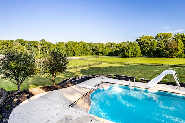 view of swimming pool with a patio, a diving board, a lawn, and a water slide