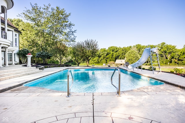 view of pool featuring a patio and a water slide