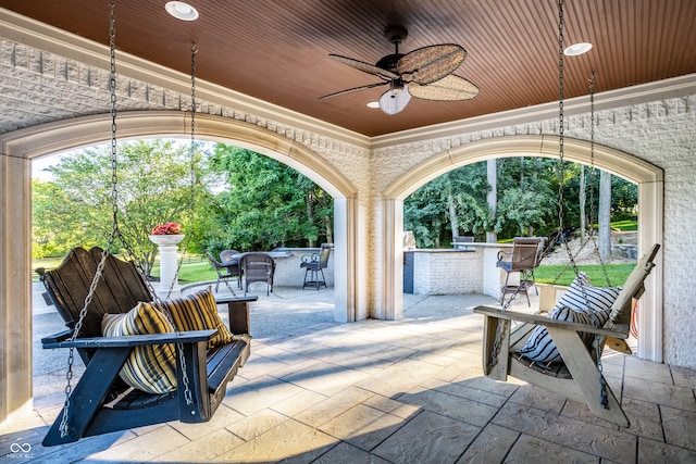 view of patio featuring area for grilling, ceiling fan, and an outdoor bar