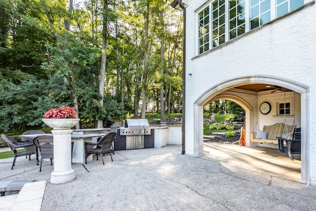 view of patio featuring an outdoor kitchen, a grill, and an outdoor bar