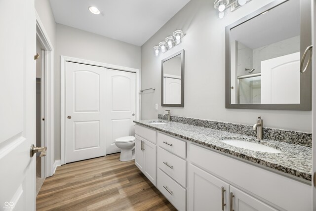 3368 Johns Way, Greenwood, IN 46143 - bathroom with double vanity, a shower with shower door, wood finished floors, and toilet