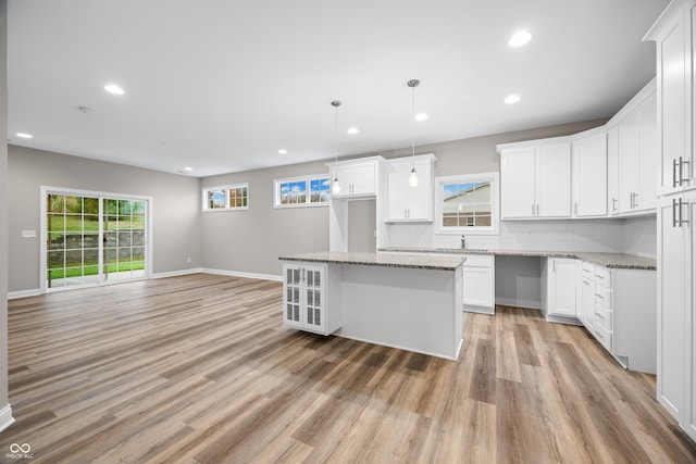 kitchen featuring a kitchen island, pendant lighting, a wealth of natural light, and white cabinets