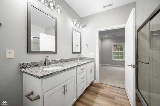 bathroom featuring an enclosed shower, vanity, and hardwood / wood-style floors