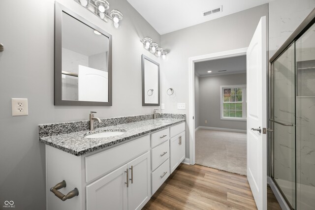 3368 Johns Way, Greenwood, IN 46143 - bathroom featuring double vanity, a marble finish shower, wood finished floors, and baseboards
