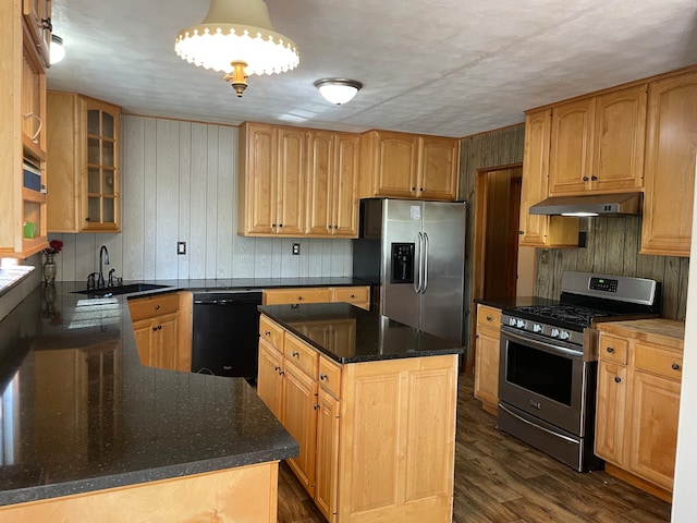 kitchen with appliances with stainless steel finishes, dark hardwood / wood-style floors, a kitchen island, a textured ceiling, and sink