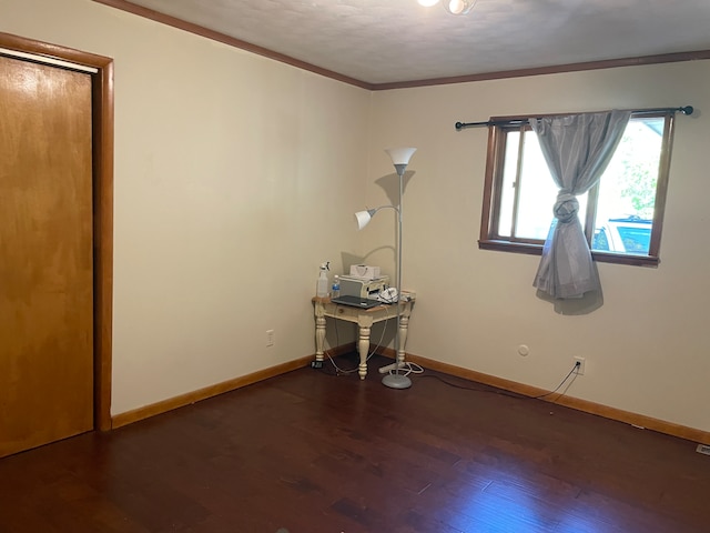 empty room with dark hardwood / wood-style flooring and crown molding