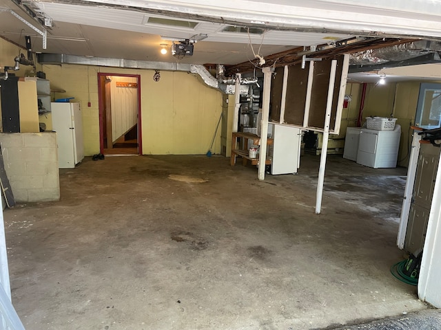 basement featuring independent washer and dryer and white refrigerator