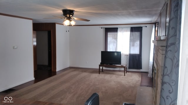 unfurnished living room featuring ceiling fan, crown molding, and carpet flooring