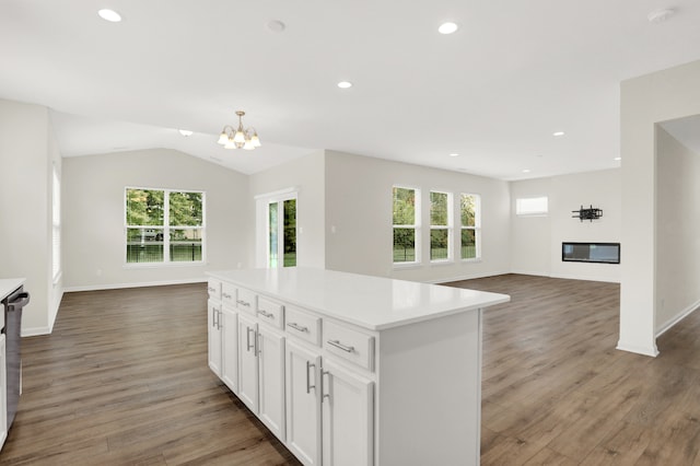 kitchen featuring an inviting chandelier, dark wood-type flooring, white cabinets, a center island, and pendant lighting