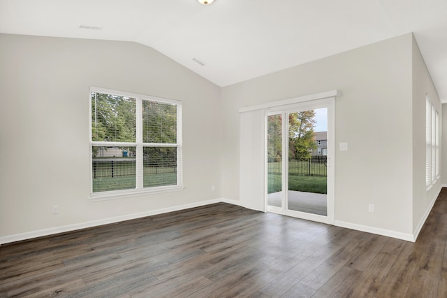 spare room with dark wood-type flooring and vaulted ceiling