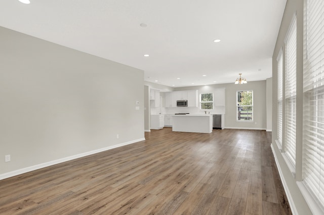 unfurnished living room with a chandelier and hardwood / wood-style flooring