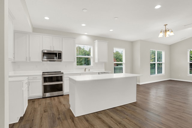 kitchen with plenty of natural light, dark hardwood / wood-style floors, stainless steel appliances, and white cabinets