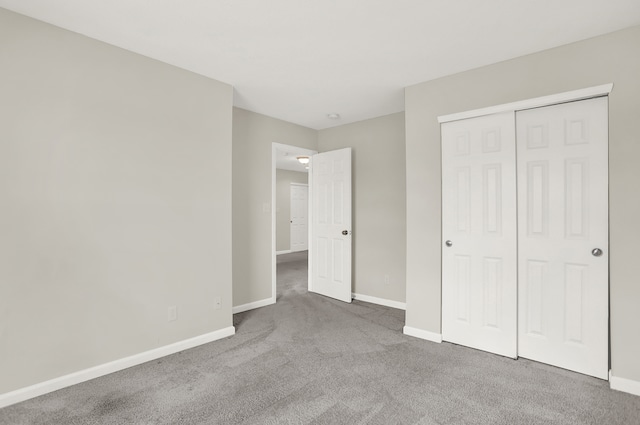 unfurnished bedroom with a closet and dark carpet