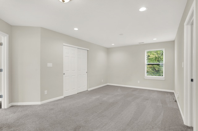 spare room featuring light carpet