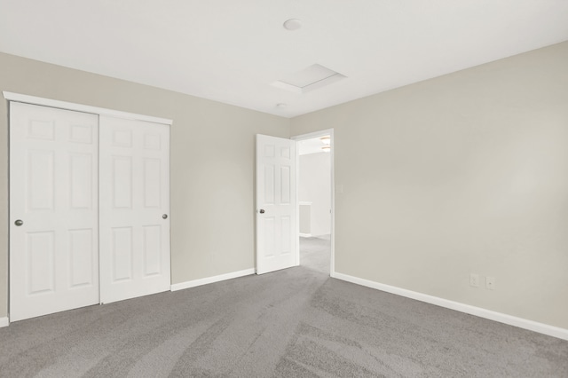 unfurnished bedroom with dark colored carpet and a closet