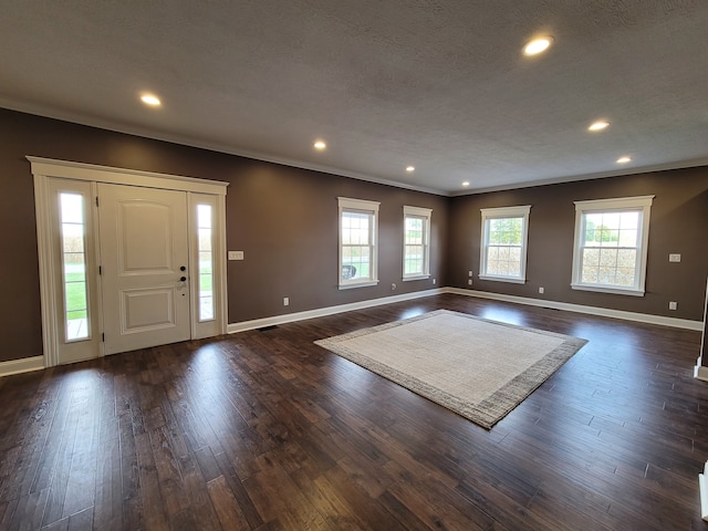 foyer entrance with ornamental molding, a textured ceiling, and dark hardwood / wood-style flooring