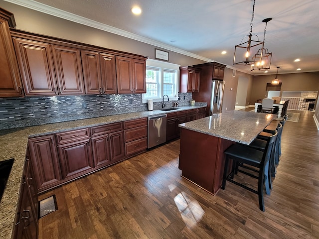 kitchen with dark wood-type flooring, a kitchen breakfast bar, stainless steel appliances, a center island, and tasteful backsplash