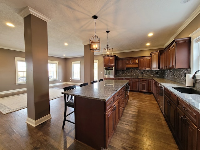 kitchen featuring dark hardwood / wood-style floors, a center island, sink, and stainless steel appliances