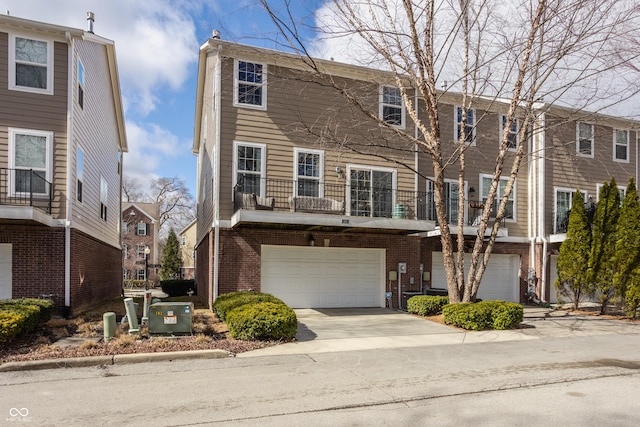 view of property featuring brick siding, driveway, and a garage