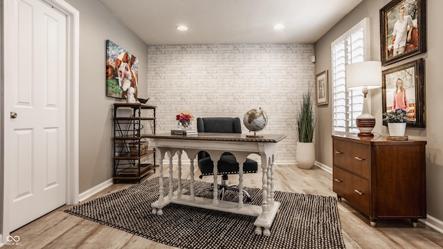 office space with recessed lighting, baseboards, light wood-style flooring, and brick wall