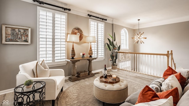 living area with crown molding, wood finished floors, a healthy amount of sunlight, and a chandelier