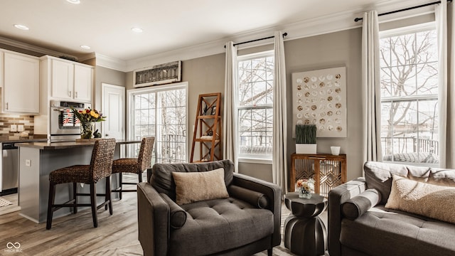 living area with light wood finished floors, recessed lighting, and crown molding