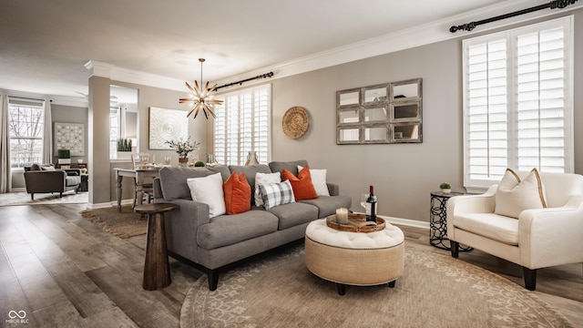 living room featuring crown molding, baseboards, and wood finished floors