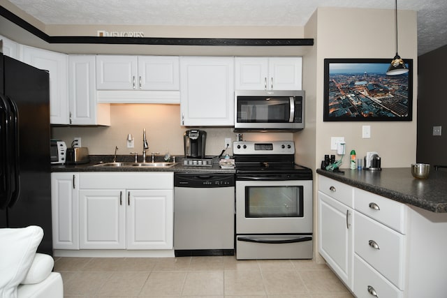 kitchen featuring white cabinets, decorative light fixtures, appliances with stainless steel finishes, and sink