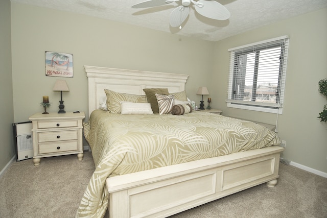 bedroom with light carpet, ceiling fan, and a textured ceiling