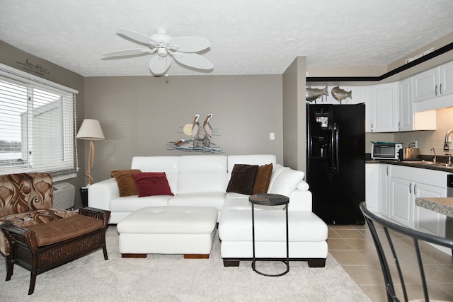 tiled living room featuring a textured ceiling, sink, and ceiling fan