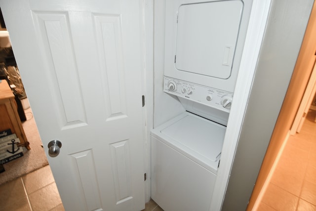 laundry area featuring tile patterned floors and stacked washing maching and dryer