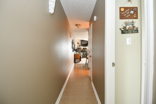 hallway with tile patterned floors and a textured ceiling