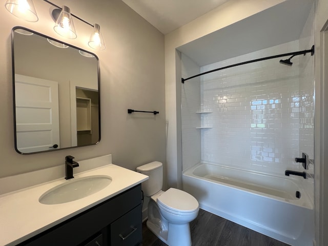 full bathroom featuring hardwood / wood-style flooring, vanity, toilet, and tiled shower / bath