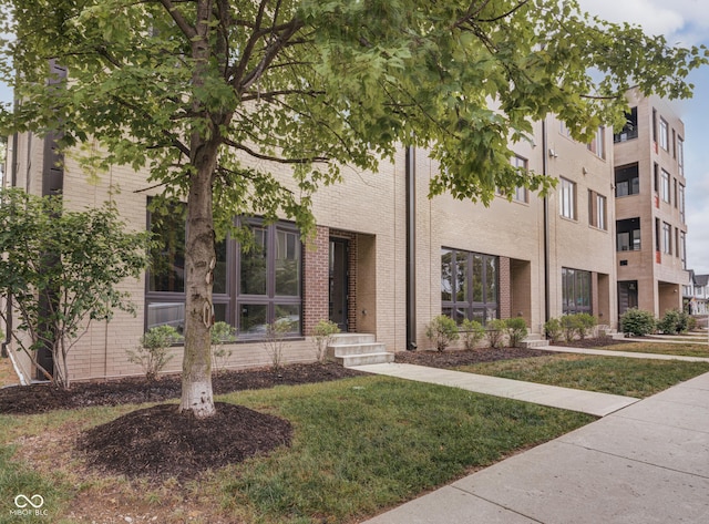 319 E 16th St Unit 207, Indianapolis, IN 46202 - townhome / multi-family property featuring a front yard and brick siding