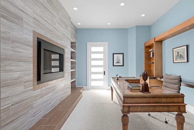 office space featuring carpet, a tiled fireplace, and recessed lighting