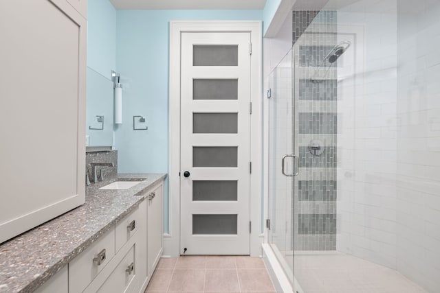 bathroom featuring tile patterned flooring, a shower stall, and vanity